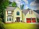 Charming two-story home with yellow siding, red shutters and garage doors, and a well-manicured lawn at 475 Cascade Rise, South Fulton, GA 30331