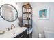 Modern bathroom features a round mirror, wood cabinet storage and brushed gold faucet at 666 Serramonte Drive Dr, Marietta, GA 30068