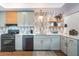 Charming kitchen featuring light blue cabinets, modern appliances, light wood accents and decorative shelving at 666 Serramonte Dr, Marietta, GA 30068