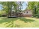 A brick home with a wooden deck is surrounded by a spacious yard and lush greenery at 2863 Jordan Forest Trl, Lawrenceville, GA 30044