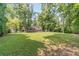 Expansive backyard with a well-maintained lawn, trees, and a view of the home at 2863 Jordan Forest Trl, Lawrenceville, GA 30044