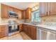 Kitchen featuring custom wood cabinets, tile backsplash, and stainless steel appliances at 2863 Jordan Forest Trl, Lawrenceville, GA 30044