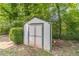 Storage shed in backyard with white painted wood siding and green trim at 2863 Jordan Forest Trl, Lawrenceville, GA 30044