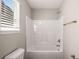 Bathroom featuring a shower-tub, neutral walls, and a window at 325 Nutwood Trce, Locust Grove, GA 30248