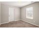 Bedroom with carpet, neutral walls, a window, and a white door at 325 Nutwood Trce, Locust Grove, GA 30248