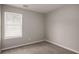 Neutral bedroom with plush carpet, window and blinds, creating a serene and simple living space at 325 Nutwood Trce, Locust Grove, GA 30248