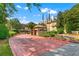 Community entrance with a guard house, well-maintained landscaping, and a paved brick driveway at 3777 Peachtree Ne Rd # 1313, Brookhaven, GA 30319