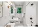 Bright bathroom featuring a pedestal sink, decorative mirror, and a shower with white subway tile at 68 Peachtree Memorial Nw Dr # 68-1, Atlanta, GA 30309