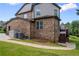 Brick home's backyard with a patio, lush green lawn, and well-maintained landscaping at 8920 Ellesmere Dr, Cumming, GA 30041