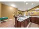 Finished basement wet bar with granite countertops, wooden cabinets, and open layout into basement seating area at 8920 Ellesmere Dr, Cumming, GA 30041
