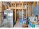 Unfinished basement featuring a stainless steel refrigerator and a framed storage area at 8920 Ellesmere Dr, Cumming, GA 30041