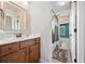Bathroom with wood vanity, white countertops, decorative mirror and tiled shower at 8920 Ellesmere Dr, Cumming, GA 30041