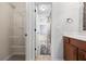 Bathroom with white vanity, neutral tile flooring, and open shelved closet space at 8920 Ellesmere Dr, Cumming, GA 30041