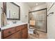 Well-lit bathroom features a glass shower door, single sink vanity, and neutral tile at 8920 Ellesmere Dr, Cumming, GA 30041