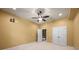 Bedroom with neutral colored walls and carpet flooring, featuring a ceiling fan and closet at 8920 Ellesmere Dr, Cumming, GA 30041