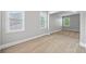 Spacious bedroom featuring three large windows, neutral carpet, and light gray walls at 8920 Ellesmere Dr, Cumming, GA 30041
