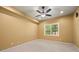 Bedroom with neutral colored walls and carpet flooring featuring a ceiling fan and window at 8920 Ellesmere Dr, Cumming, GA 30041