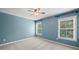 Bedroom with gray carpet, blue walls, and natural light from two windows at 8920 Ellesmere Dr, Cumming, GA 30041