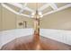 Formal dining room with coffered ceiling, wainscoting and chandelier at 8920 Ellesmere Dr, Cumming, GA 30041