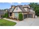 Stunning home featuring a two-car garage with ample driveway space and lush landscaping for added privacy at 8920 Ellesmere Dr, Cumming, GA 30041