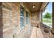 Charming covered porch features decorative brickwork, creating an inviting outdoor space with shaded comfort at 8920 Ellesmere Dr, Cumming, GA 30041