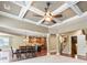 Elegant living room featuring a coffered ceiling, open layout, and seamless transition to the dining area and kitchen at 8920 Ellesmere Dr, Cumming, GA 30041