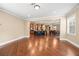 Open-concept living room with beautiful hardwood floors connected to the kitchen and dining area at 8920 Ellesmere Dr, Cumming, GA 30041