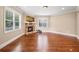 Bright living room featuring a stone fireplace, wood flooring, and large windows for ample natural light at 8920 Ellesmere Dr, Cumming, GA 30041