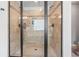The walk-in shower is enclosed with sleek glass and finished with bronze fixtures at 8920 Ellesmere Dr, Cumming, GA 30041