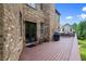 Wooden deck is furnished with seating, a grill, and black double door access to home's interior at 8920 Ellesmere Dr, Cumming, GA 30041