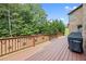 Wooden deck is furnished with a grill, and overlooks green backyard and mature trees at 8920 Ellesmere Dr, Cumming, GA 30041