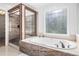 An opulent bathroom with tub and shower, and beautiful window at 4837 Mystere Sw Cir, Lilburn, GA 30047