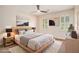 A bright bedroom with a fan, bed, nightstands, and art at 4837 Mystere Sw Cir, Lilburn, GA 30047