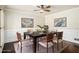 Elegant dining room featuring hardwood floors, wainscoting, contemporary art, and a ceiling fan at 4837 Mystere Sw Cir, Lilburn, GA 30047