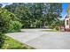 Large concrete driveway surrounded by lush landscaping at 4837 Mystere Sw Cir, Lilburn, GA 30047