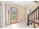 Inviting foyer with tile flooring, glass-paneled door, staircase, and elegant light fixture at 4837 Mystere Sw Cir, Lilburn, GA 30047