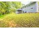 Expansive backyard featuring lush greenery, a deck, and a charming home exterior at 6662 Birchwood Ct, Winston, GA 30187
