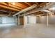 The unfinished basement has concrete floors, exposed ductwork and beams and white painted walls at 6662 Birchwood Ct, Winston, GA 30187