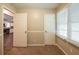 This bedroom features neutral paint, carpet flooring, and a view into the kitchen at 6662 Birchwood Ct, Winston, GA 30187