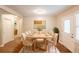 Bright dining room with a modern table set for eight, hardwood floors, a decorative rug, and a large window at 6662 Birchwood Ct, Winston, GA 30187
