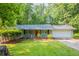 Charming single-story home featuring a well-manicured lawn, attached garage, and cozy front porch entry with a bright red door at 6662 Birchwood Ct, Winston, GA 30187