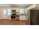 Well-equipped kitchen with stainless steel appliances, granite countertops, white cabinetry, and hardwood flooring at 6662 Birchwood Ct, Winston, GA 30187