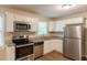 Modern kitchen featuring stainless steel appliances, granite countertops, white cabinets, and hardwood floors at 6662 Birchwood Ct, Winston, GA 30187