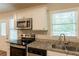 Well-lit kitchen with stainless steel appliances, including a microwave, oven, and dishwasher, complemented by granite countertops at 6662 Birchwood Ct, Winston, GA 30187