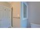 A bathroom featuring a toilet, shower with glass door, and a door to exit at 13935 Brown Bridge Rd, Covington, GA 30016