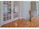 Hallway featuring hardwood flooring, detailed trim work and glass French doors for ultimate appeal and functionality at 13935 Brown Bridge Rd, Covington, GA 30016