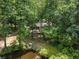 Aerial view of a property with a pond nestled amidst lush greenery and mature trees at 4025 Demooney Rd, Atlanta, GA 30349