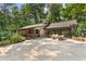 Charming single-story home featuring a large drive and outdoor seating area surrounded by lush greenery at 4025 Demooney Rd, Atlanta, GA 30349