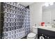 Bathroom with a patterned shower curtain, a dark tiled wall, toilet and sink at 2465 Main St # 201, Atlanta, GA 30344