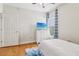 Bright bedroom featuring hardwood floors, a dresser with a TV, and a window with blue curtains at 2465 Main St # 201, Atlanta, GA 30344